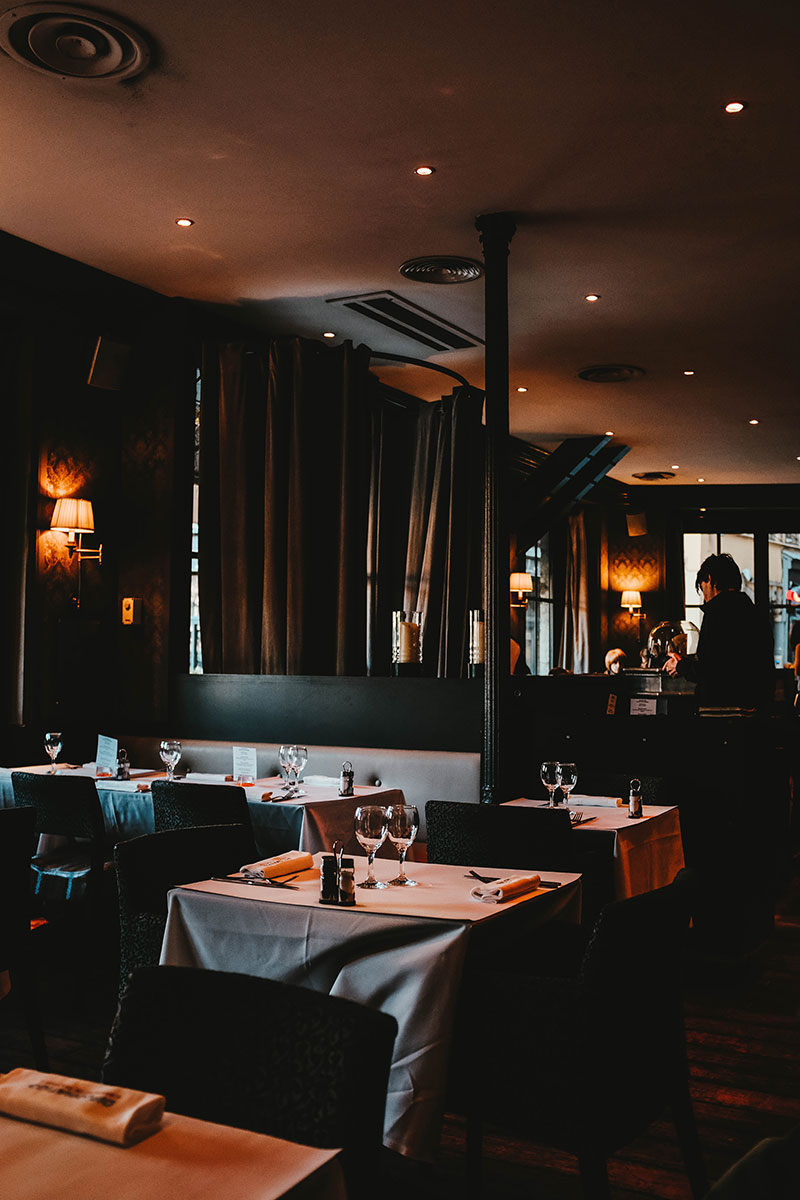 restaurant filled with chairs and tables having a black ambience and elegance